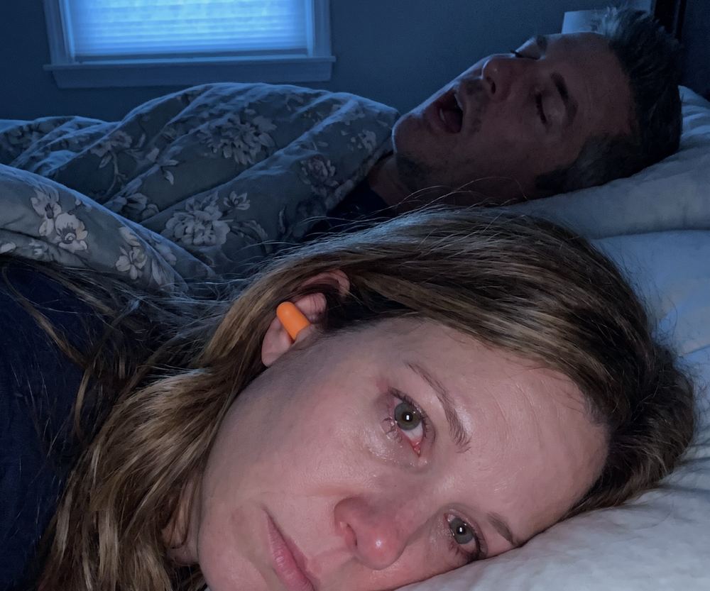 2am: she lies awake with an orange earplug in while he snores behind her